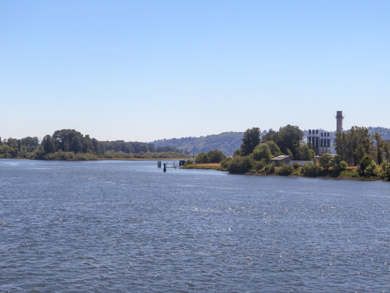 A small power plant across from an island on the Columbia River