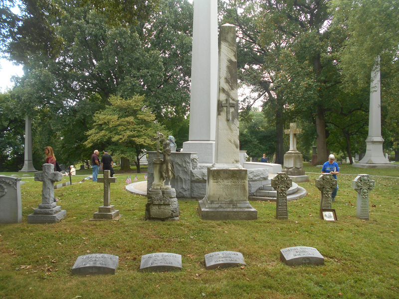 Headstone and grave markers surround a large monument at the Clark family gravesite