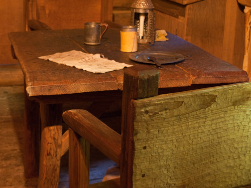 hand-hewn table and chair in a log cabin