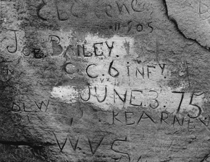 names and dates carved into a rock wall