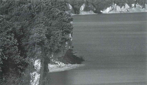 Vertical, white cliffs meeting the edge of the reservoir
