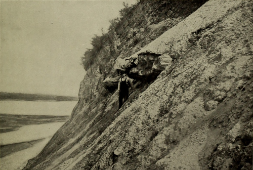A man stands on a white, steep hill overlooking the Missouri River before dams