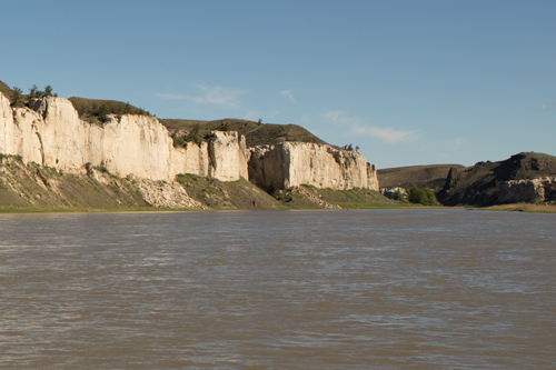 Dark hills rising behind white cliffs