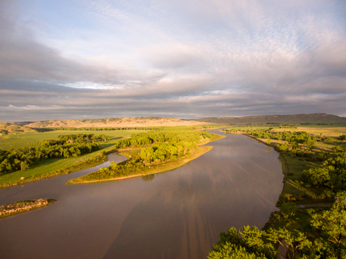 Wide, green valley surrounded by barren hills