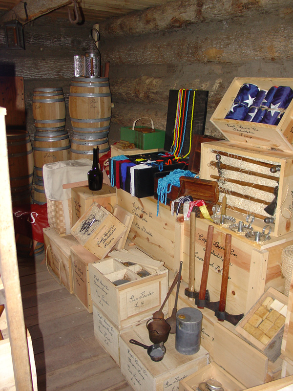 Log cabin storeroom with barrels, crates, and Indian gifts
