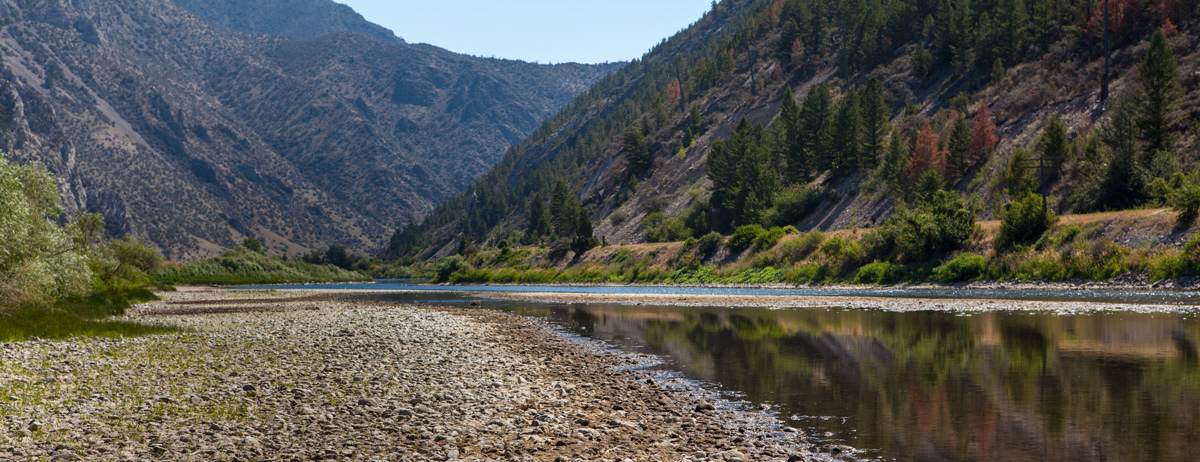 River with very rocky bottom flows through a canyon