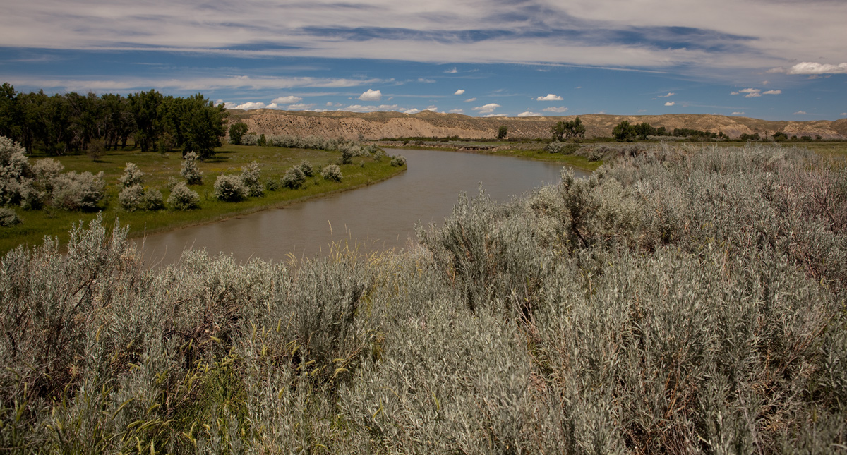 River winding through barren hills and sage brush