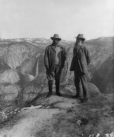 Roosevelt and Muir standing on a high rock