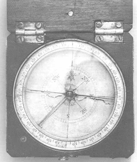 Black and white photo of an old compass in a wood box
