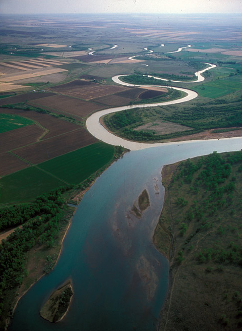 A small, crooked, and muddy river entering the blue Missouri River