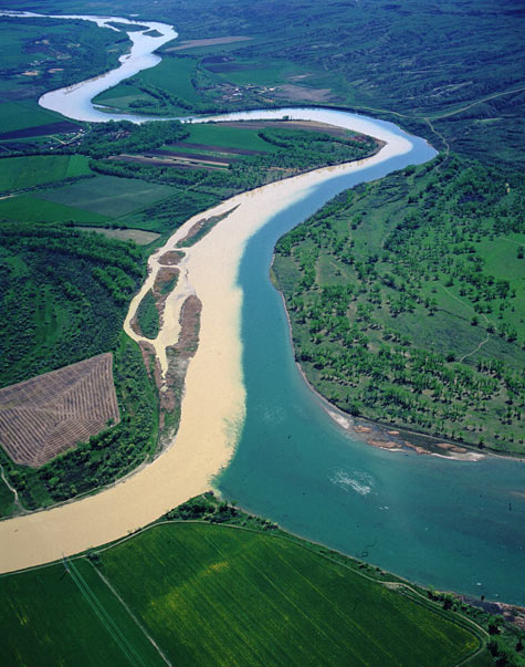 A small, crooked, and muddy river entering the blue Missouri River