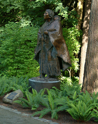 Sacagawea statue on a fern-covered hillside