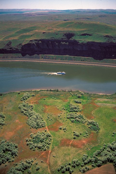 Aerial photo showing a cruise boat heading up a slackwater river where there were once Snake River rapids