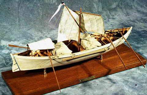 a large row boat with two sails
