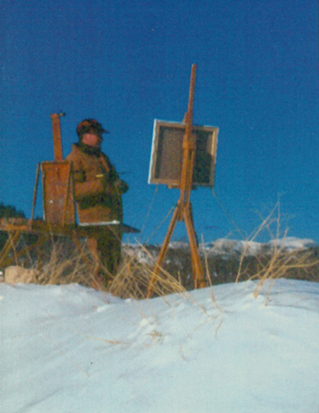 Charles Fritz with table and easel on a snow-topped hill