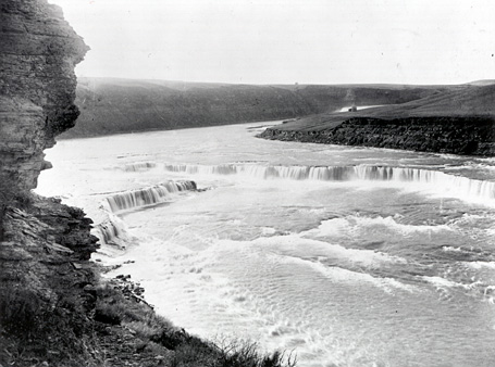 A low water fall crossing the river in an inverted 'V'