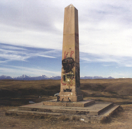 tall, modern concrete marker covered with spray paint graffiti