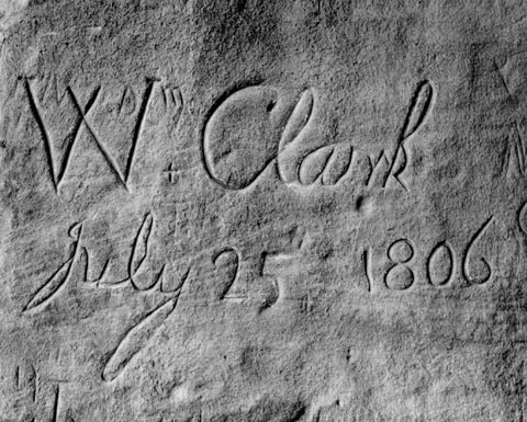 Clark's name and date in carved into a rock using a cursive script