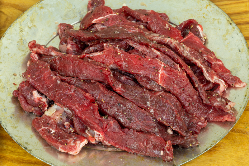 Raw, red meat cut into thin strips