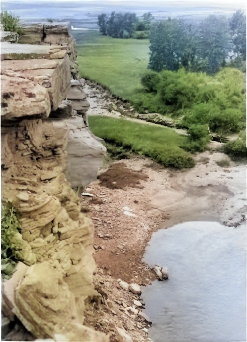 A cliff outcrop rises above Cut Bank Creek near Camp Disappointment