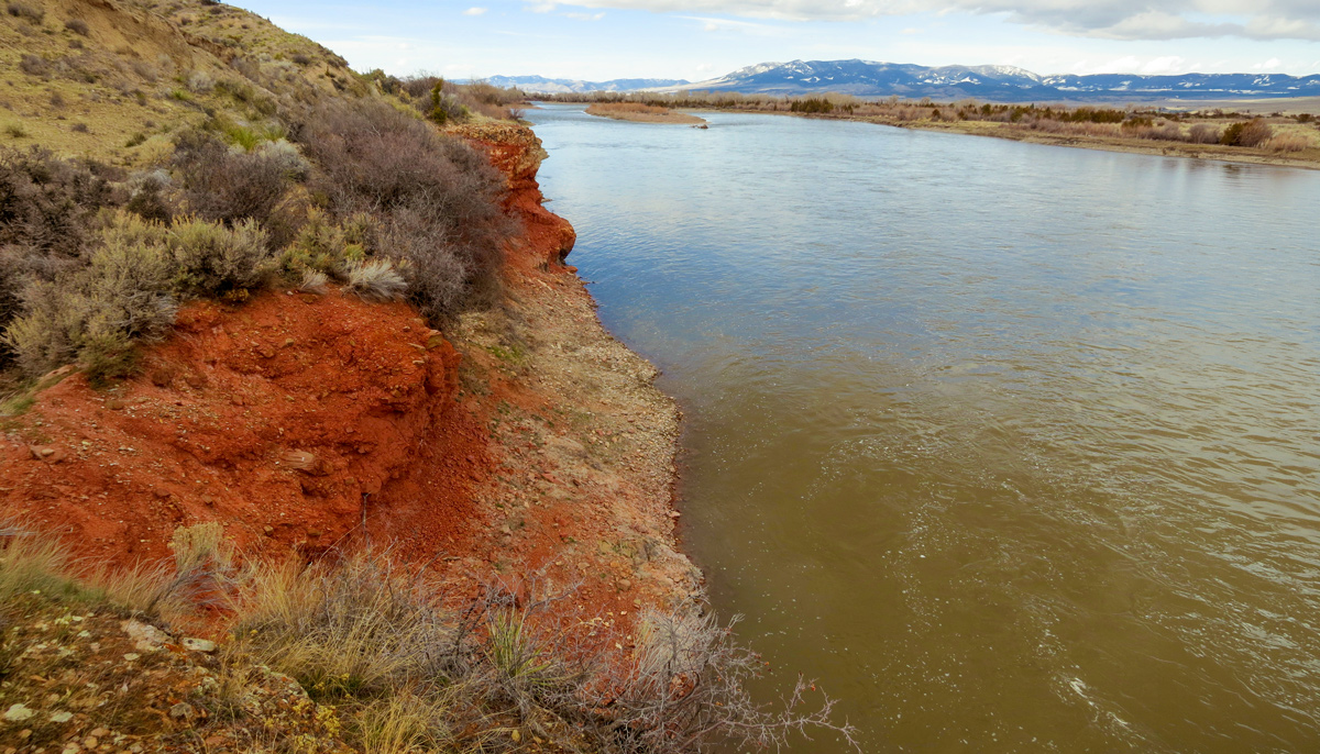 low sagebrush hills with bright red soil and rocks