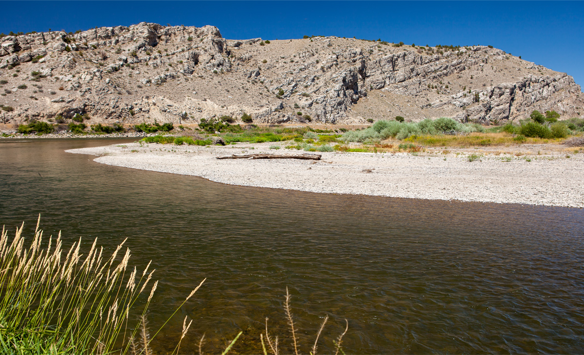 A clear river running though white limestone and sagebrush