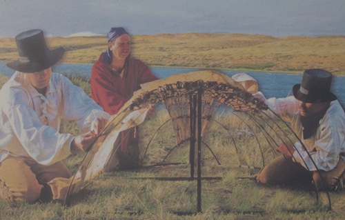 Two men sewing hides onto an iron-framed boat