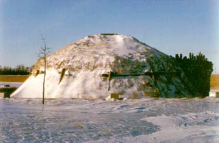 Earthen lodge covered with snow